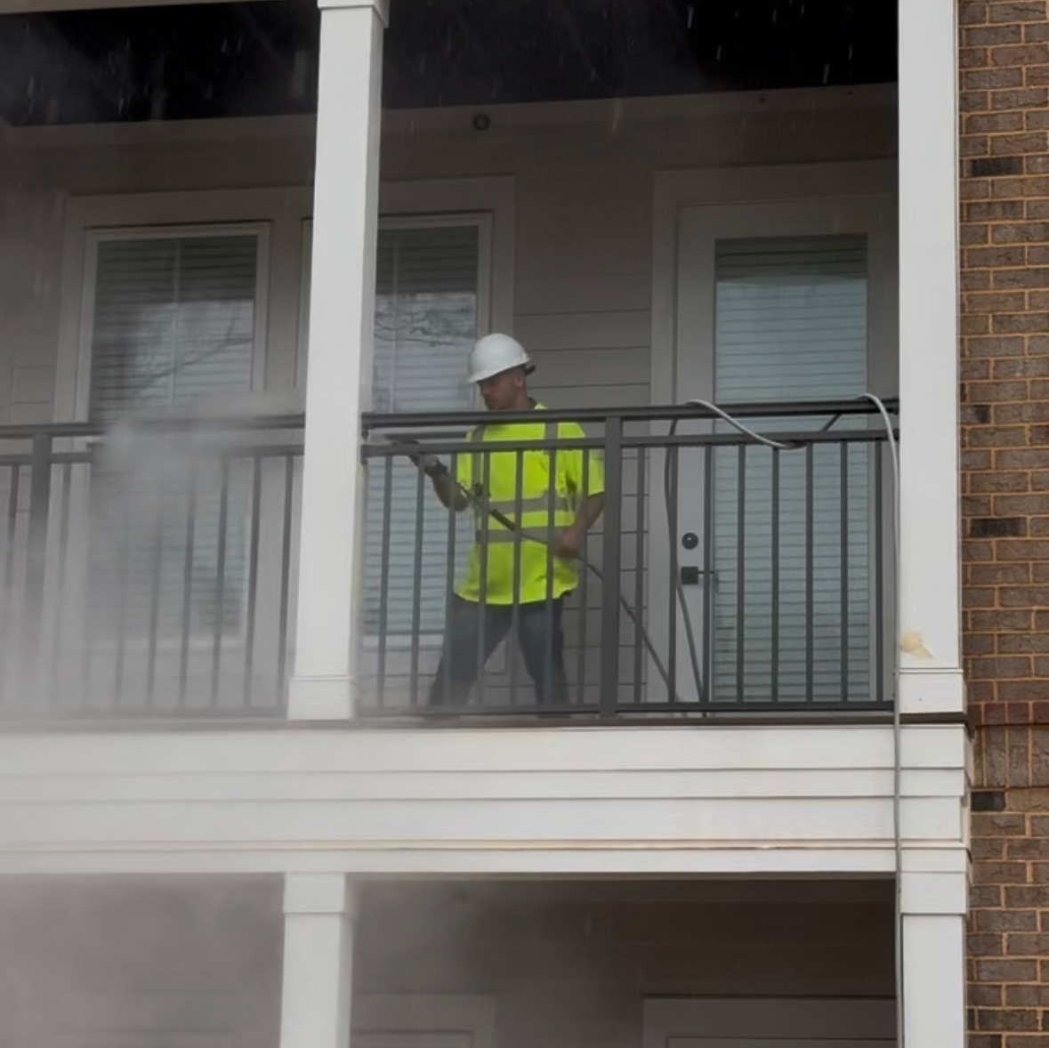 Post-construction site with power washing crew cleaning concrete